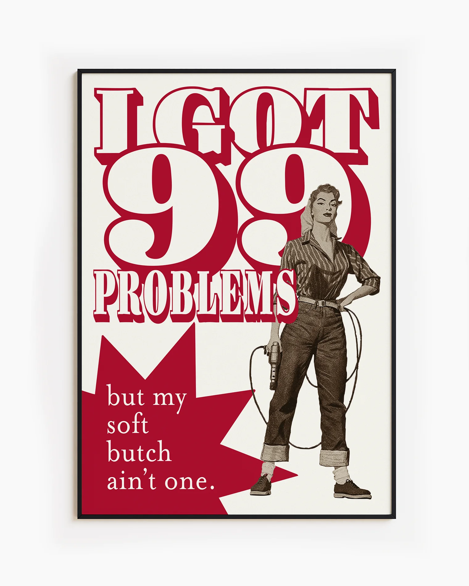 A framed poster depicting a soft butch wearing jeans and a shirt, holding a drill with the text: “I GOT 99 PROBLEMS” and “but my soft butch ain't one.”