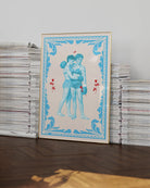 A poster that depicts two queer, muscular boxers in a romantic embrace, surrounded by red roses and a blue frame.