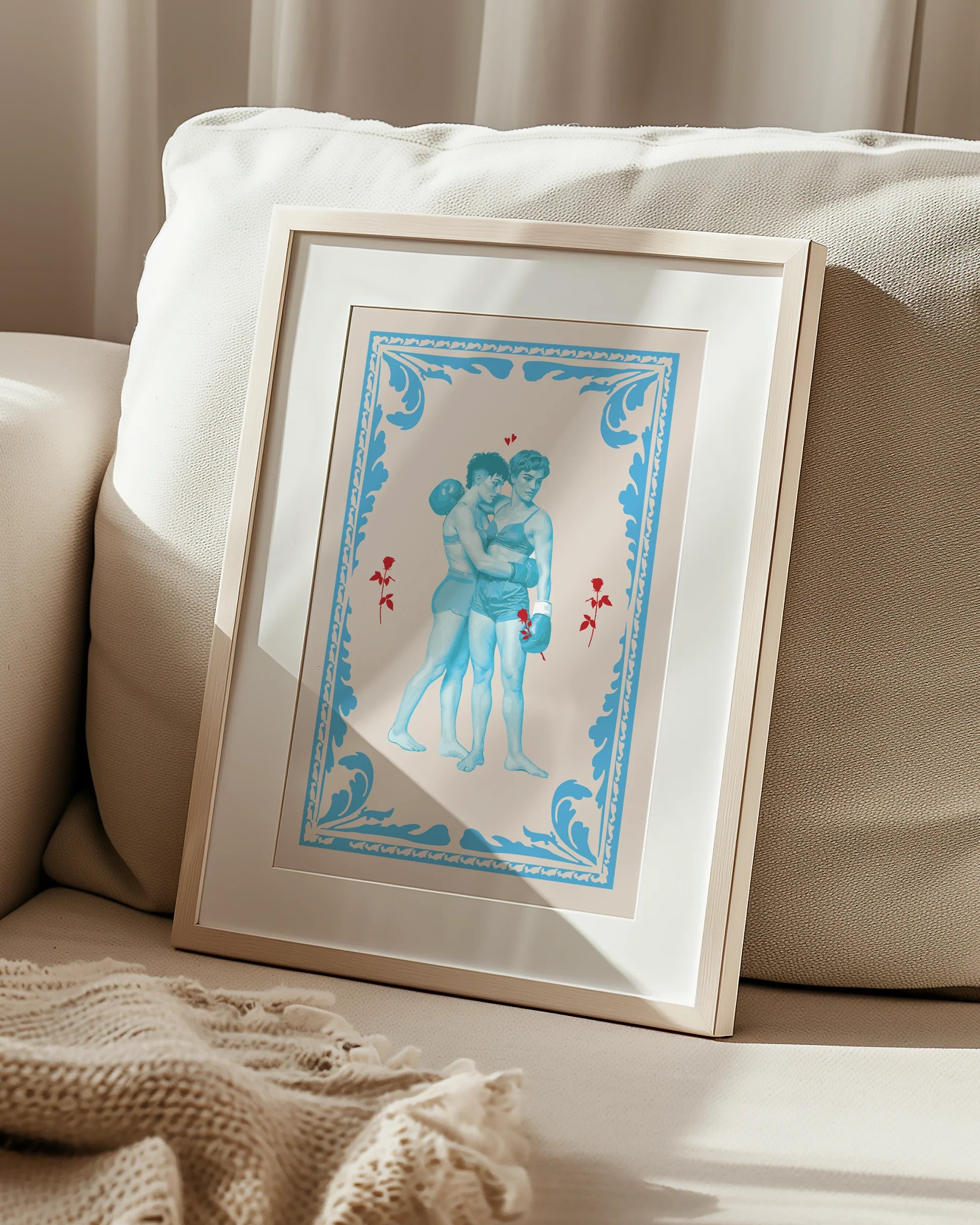 A poster that depicts two queer, muscular boxers in a romantic embrace, surrounded by red roses and a blue frame.