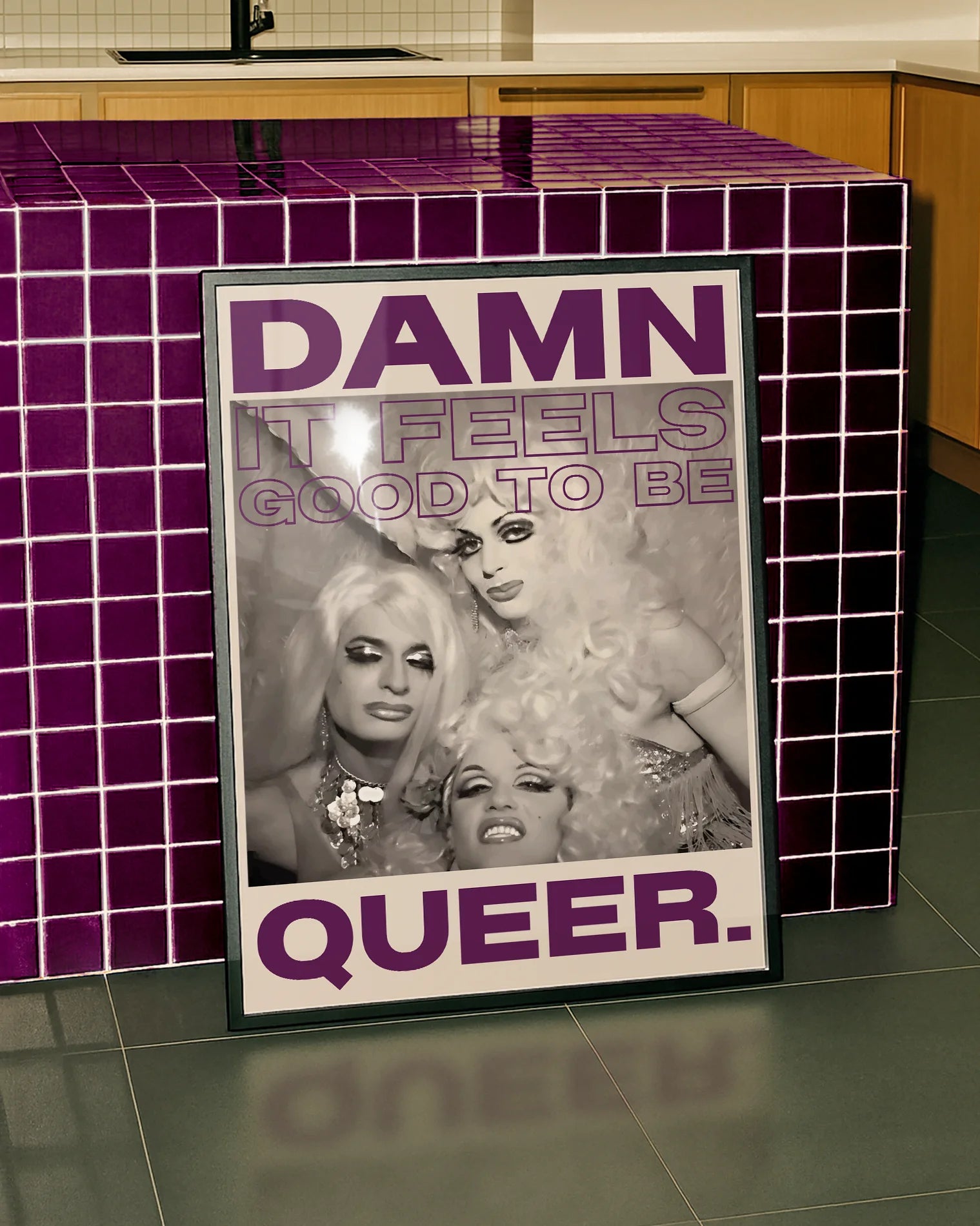 Postern föreställer tre dragqueens i en vintage fotografi-stil med texten ' DAMN IT FEELS GOOD TO BE QUEER.'