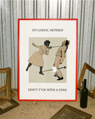 A poster with a woman fencing a man, with the text: "EN GARDE, HETERO! DON'T FUCK WITH A DYKE."