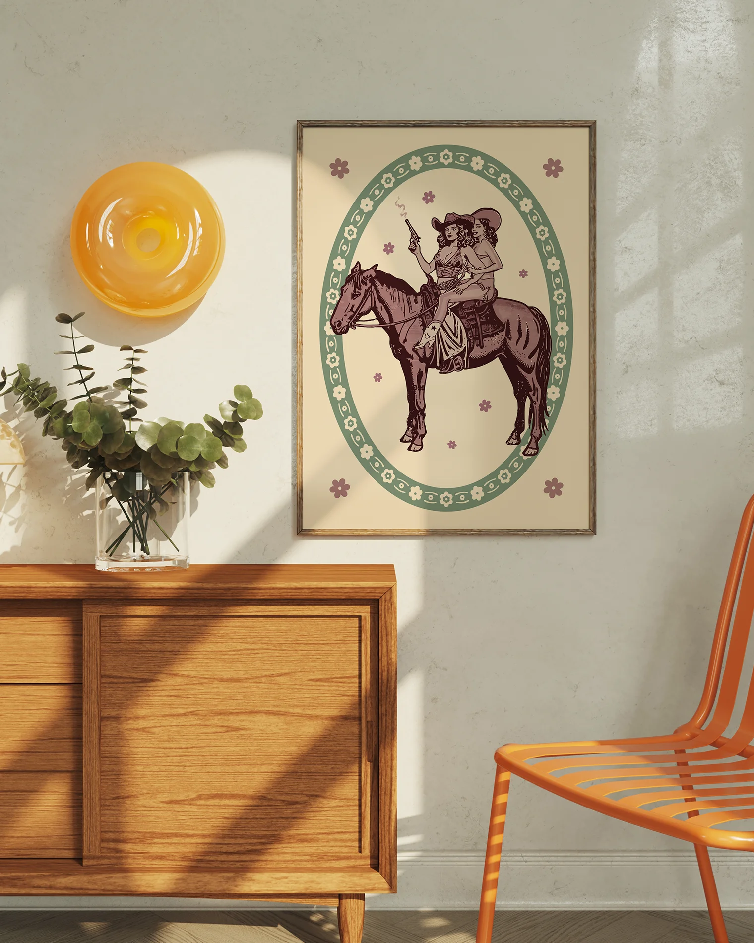 A framed poster featuring two lesbian cowgirls sitting on a horse, surrounded by a retro-style floral frame.