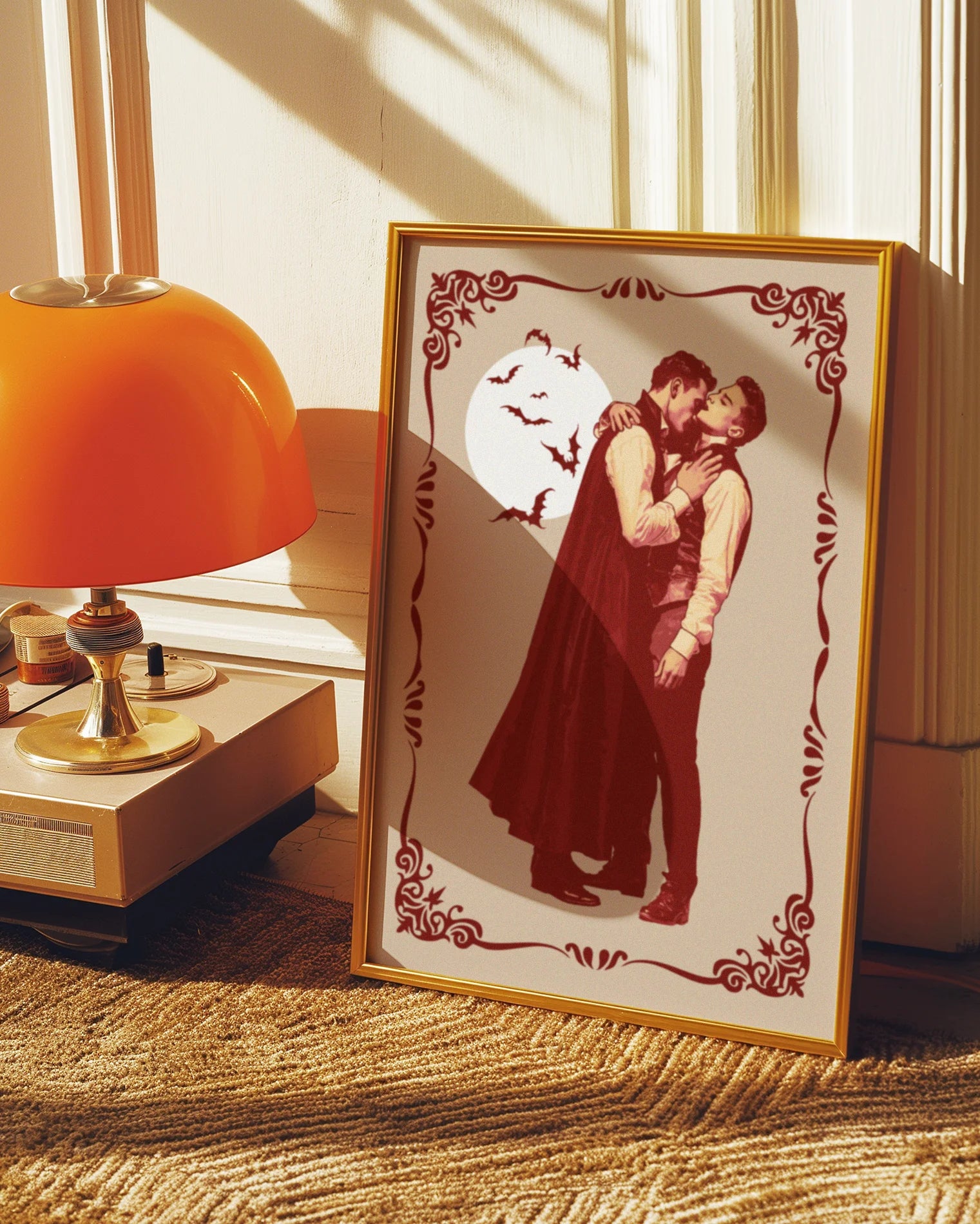 A poster featuring a male vampire kissing another man’s neck, framed by a vintage border, with a full moon and flying bats in the background.