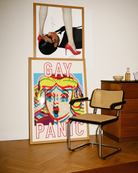 A framed poster featuring a screaming woman in pop art style with the text: *"GAY PANIC"* in red.