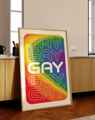 A print with a prideflag in a wavy form, with the text GAY times five.