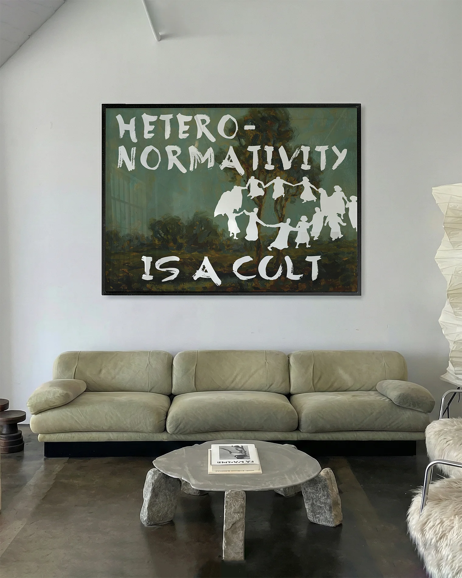 A framed poster depicting a group of people dancing in a cult-like circle, accompanied by the text “Heteronormativity Is a Cult.”