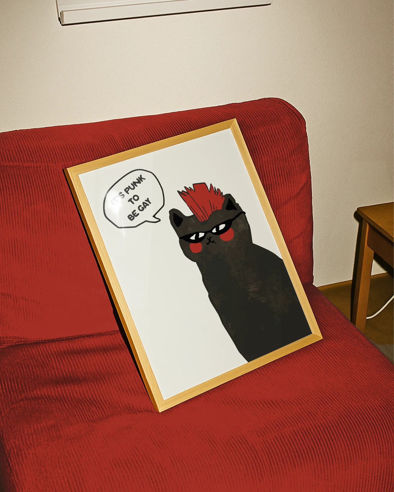 A framed print with a black, punk cat with the text 'It's punk to be gay'.