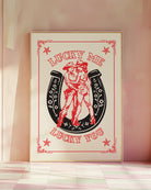 A print with an illustrated, lesbian cowgirls couple with the text 'Lucky me Lucky you.'