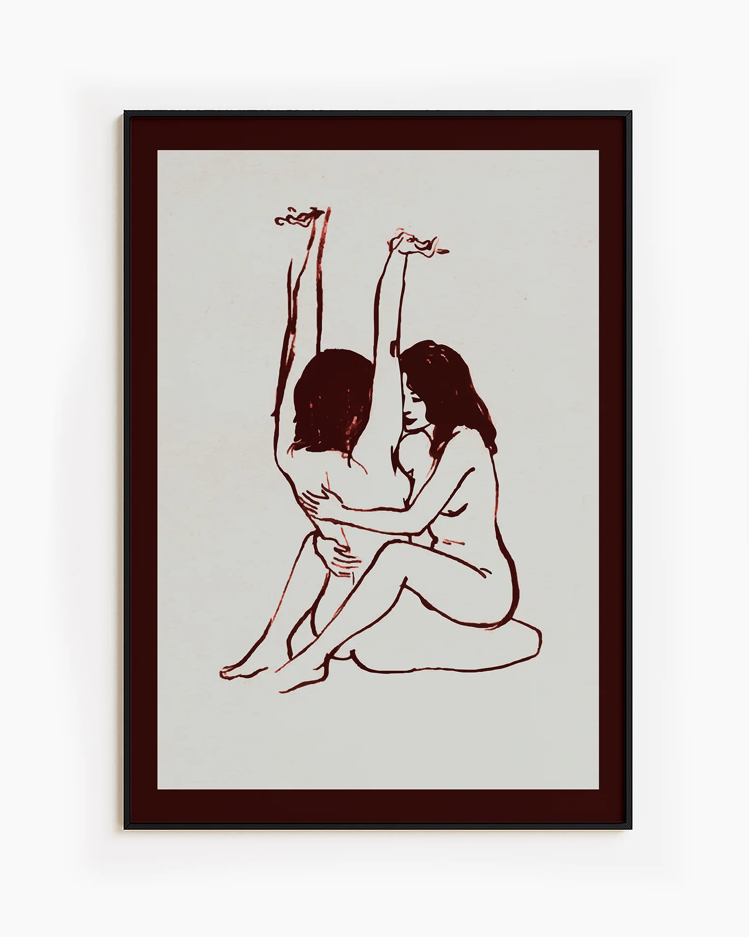 A framed print with two naked girls, hugging tight on the floor.