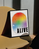 A print with the classic pride colours in an oval shape with the text 'Pride Keeps People Alive'.