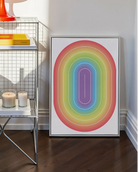 A framed print with an illustrative prideflag in an oval form.