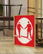 A print with an illustrated male couple in suits, walking hand in hand against a red background.