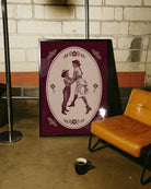 A print with two illustrated lesbian cowgirls in a loving, playful pose.