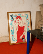 A poster with an illustrated, queer person smoking a cigarette, dressed in a red dress and heavy makeup.