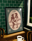 A print with an illustrated, sapphic cowgirl couple sitting on a fence.