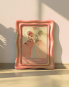 A print with a sapphic couple kissing in a tarot-style, 1700's era, with the text 'The Lovers'.