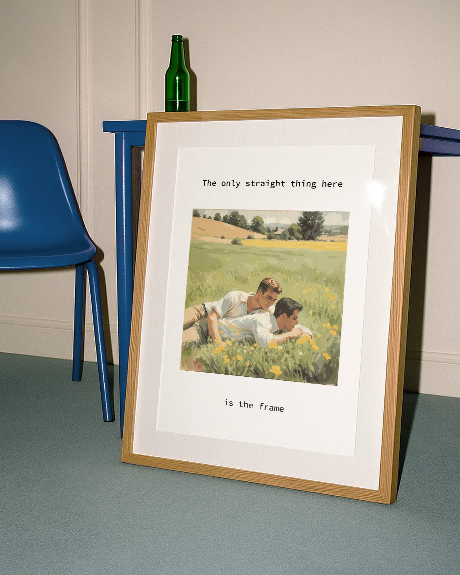 A poster with two gay men cuddling together in a summery green field of yellow flowers, with the text: “The only thing straight here is the frame.”