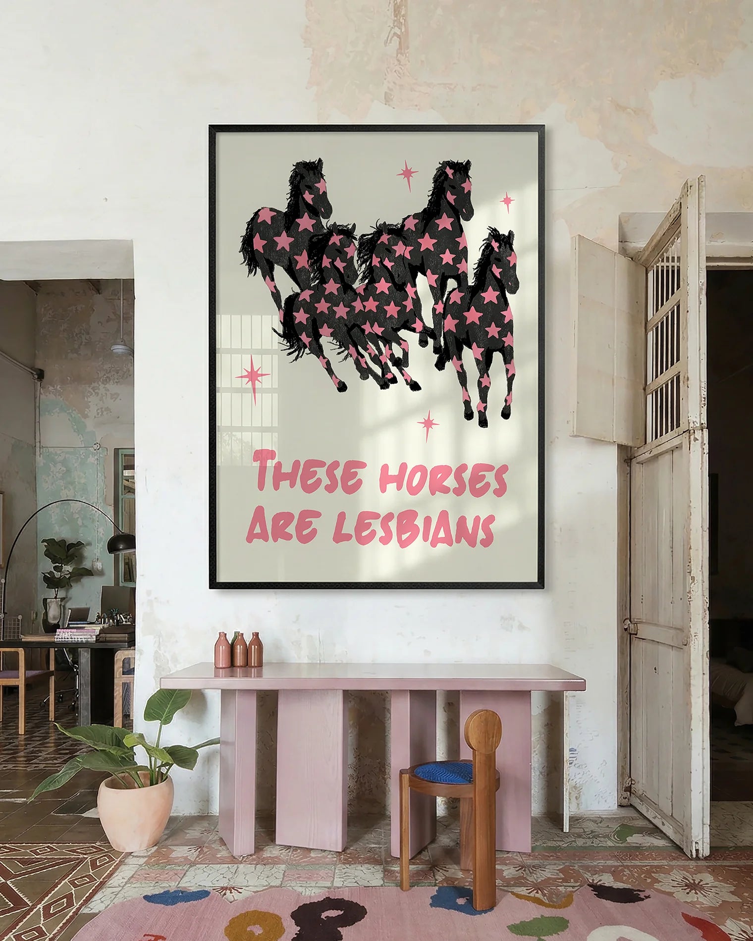 A framed poster with five horses and the text 'THESE HORSES ARE LESBIANS'.