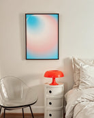 A framed print with a round, gradient form in the transflag colours blue, pink and white.