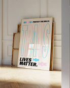 A print with the text 'Trans Lives Matter', with the transgender pride flag colours.