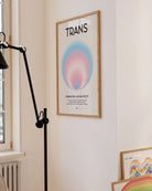 Framed, abstract poster with a circle in the transflag colours with a describing text about being transgender.
