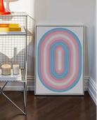 A framed print with a transgender, illustrative flag in an oval form.
