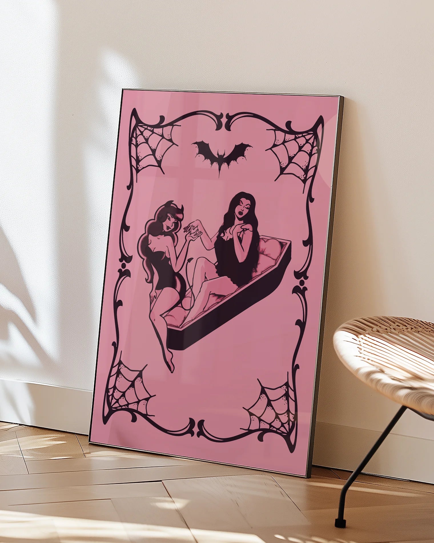 A poster featuring a female devil sitting on the edge of a coffin, while a female vampire sits inside. They hold each other’s hands romantically, creating a mysterious and intimate atmosphere.