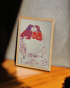 A framed poster with a sketched, lesbian cute couple kissing at a café.
