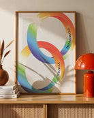 A print with two illustrated, shiny engagement rings in smooth pride colours with the engraved text 'Forever yours'.