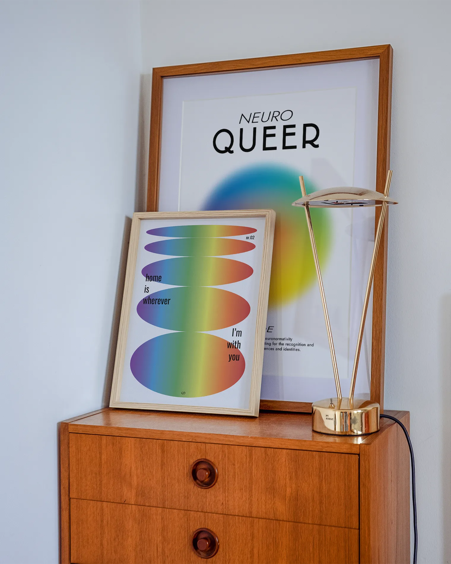 A gallery wall with two pride themed prints.