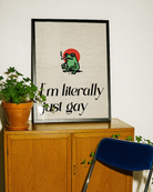 A framed poster with a cute, green, smoking frog with the text 'I´m literally just gay'.