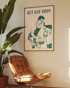 A poster depicting a male nurse taking care of a sick, bedridden man, accompanied by the ironic text: “GET GAY SOON.”