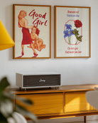 The poster depicting a woman standing in front of her lover, who kneels and looks up at her with a smile, accompanied by the text 'Good Girl'.