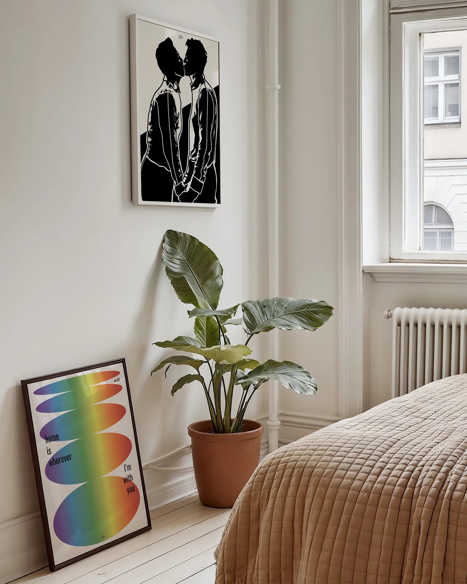 Two posters with a silhouette of two men kissing and an abstract pride poster.