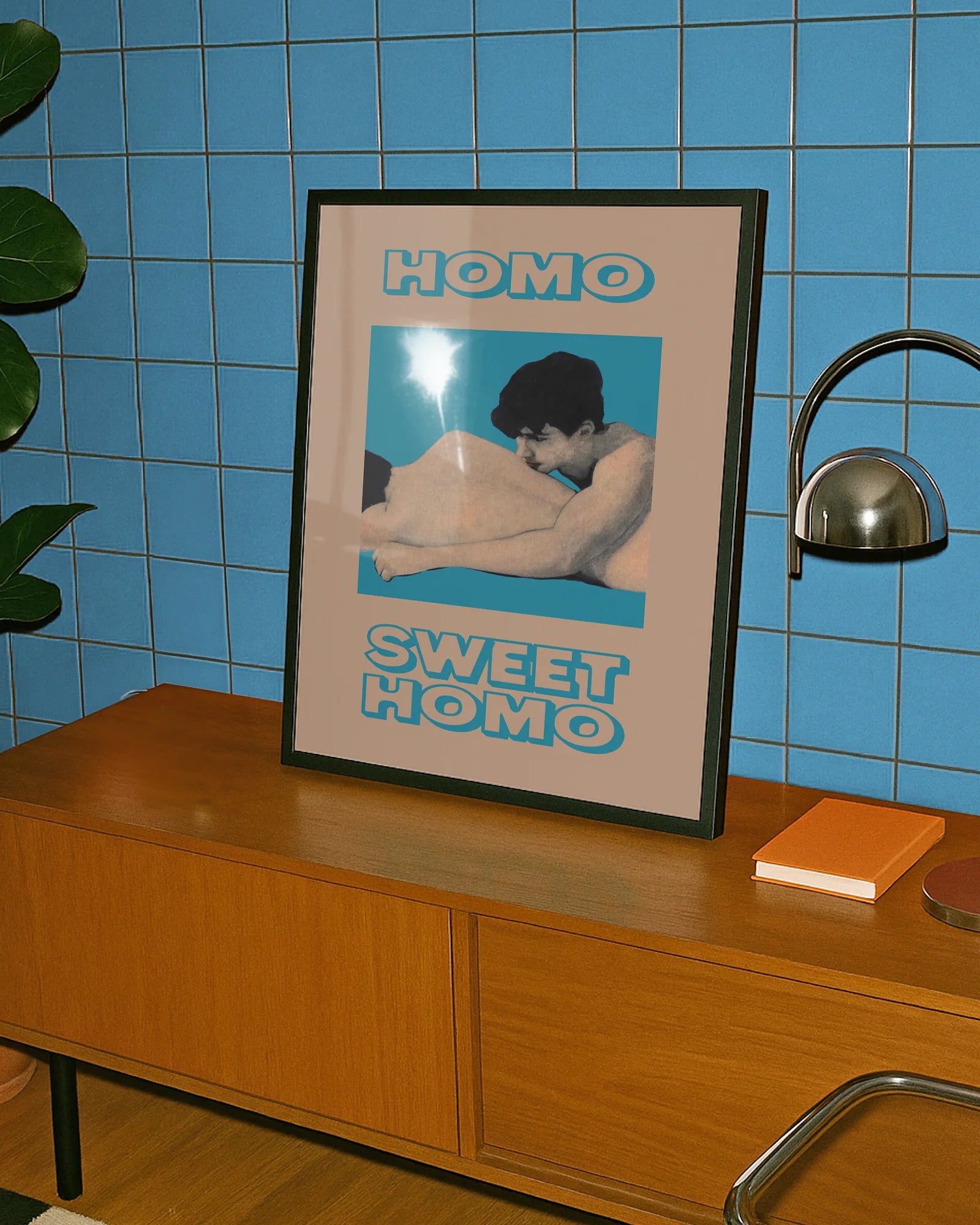 A framed poster featuring two naked men lying closely together in a soft and romantic pose, with the text: “HOMO SWEET HOMO.”