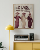 A poster with three ladies in vintage style holding binoculars with the text 'In a room full of people, I look for lesbians'.