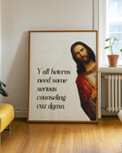 A framed poster with Jesus saying "Y'all heteros need some serious counseling cuz damn."