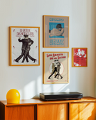 A framed print depicting two dancing gay men in a vintage, retro style, featuring the text “LE QUEER DANCECLUB” and “Gentlemen Society Since 1932.”