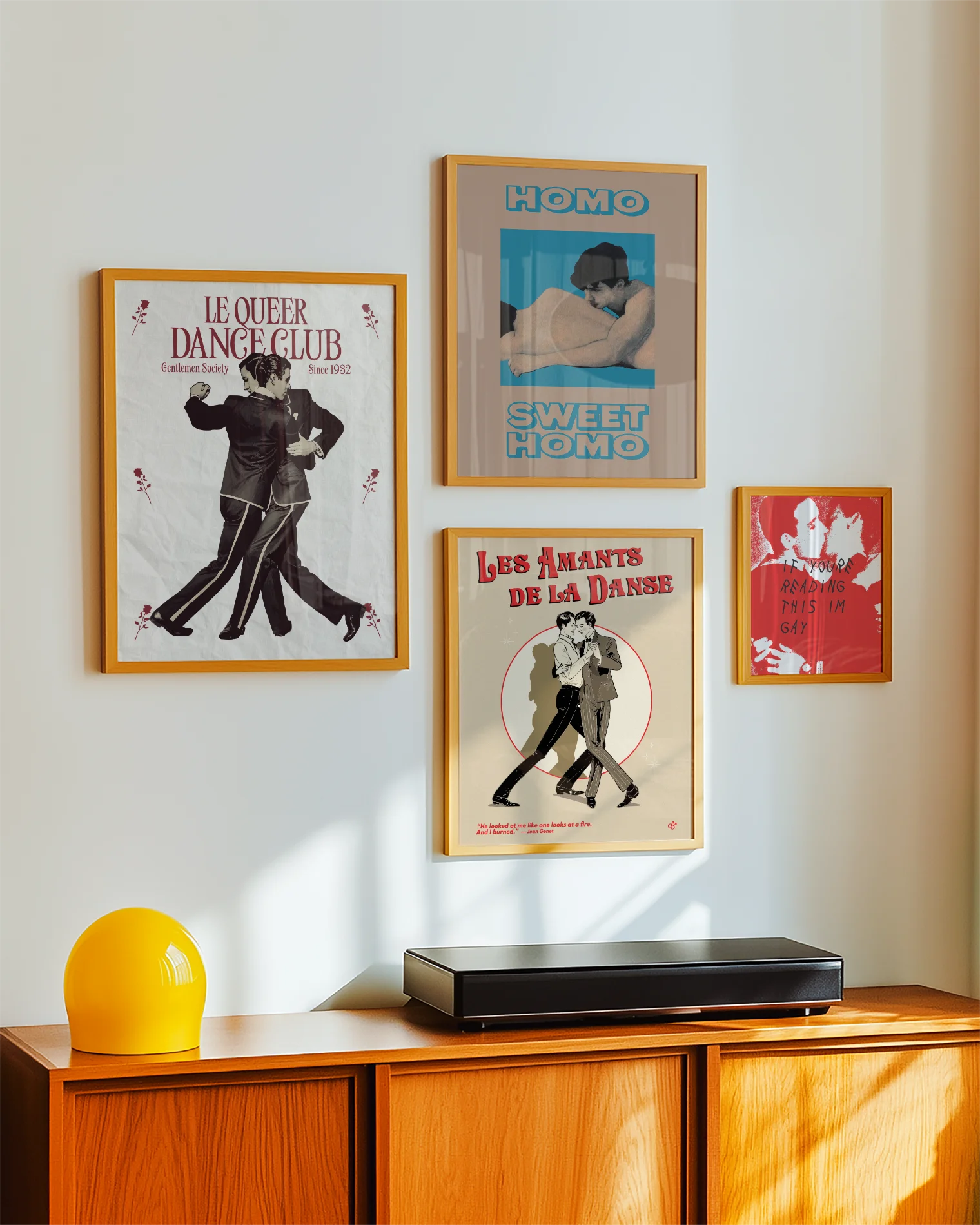 A framed print depicting two dancing gay men in a vintage, retro style, featuring the text “LE QUEER DANCECLUB” and “Gentlemen Society Since 1932.”