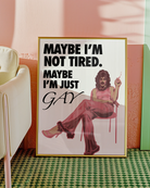 The poster features a fabulous person in pink clothing, heels and a 70s hairstyle with the text 'MAYBE I'M NOT TIRED. MAYBE I'M JUST GAY.'