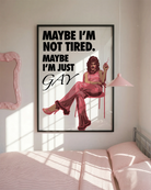 The poster features a fabulous person in pink clothing, heels and a 70s hairstyle with the text 'MAYBE I'M NOT TIRED. MAYBE I'M JUST GAY.'