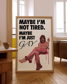 The poster features a fabulous person in pink clothing, heels and a 70s hairstyle with the text 'MAYBE I'M NOT TIRED. MAYBE I'M JUST GAY.'