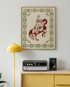 A framed poster with two, naked cowgirls riding a horse.