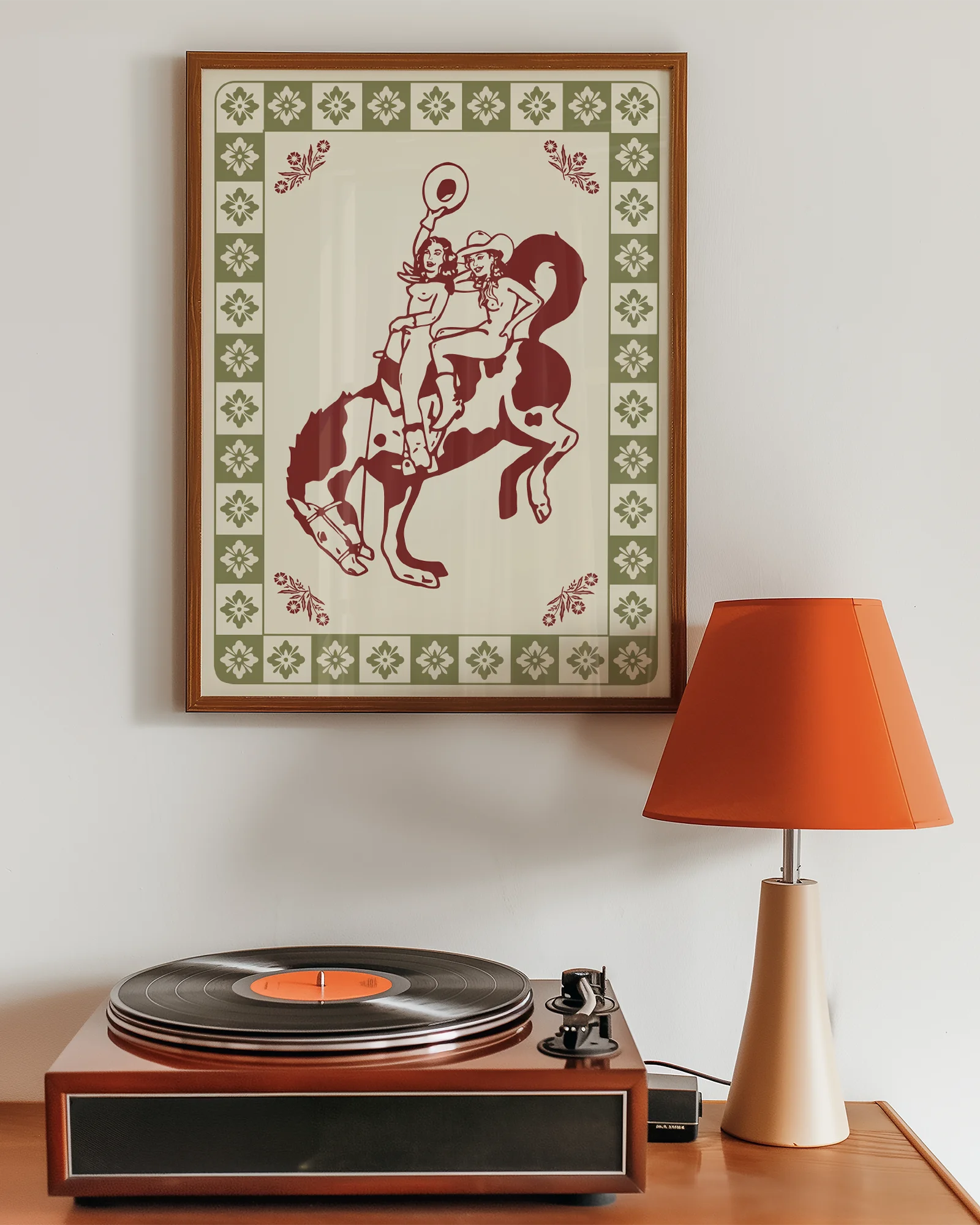 A framed poster with two, naked cowgirls riding a horse.