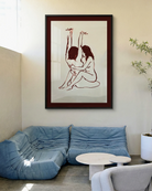A framed print with two naked girls, hugging tight on the floor.