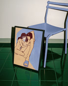 A framed poster with a lesbian, naked couple in an abstract style.