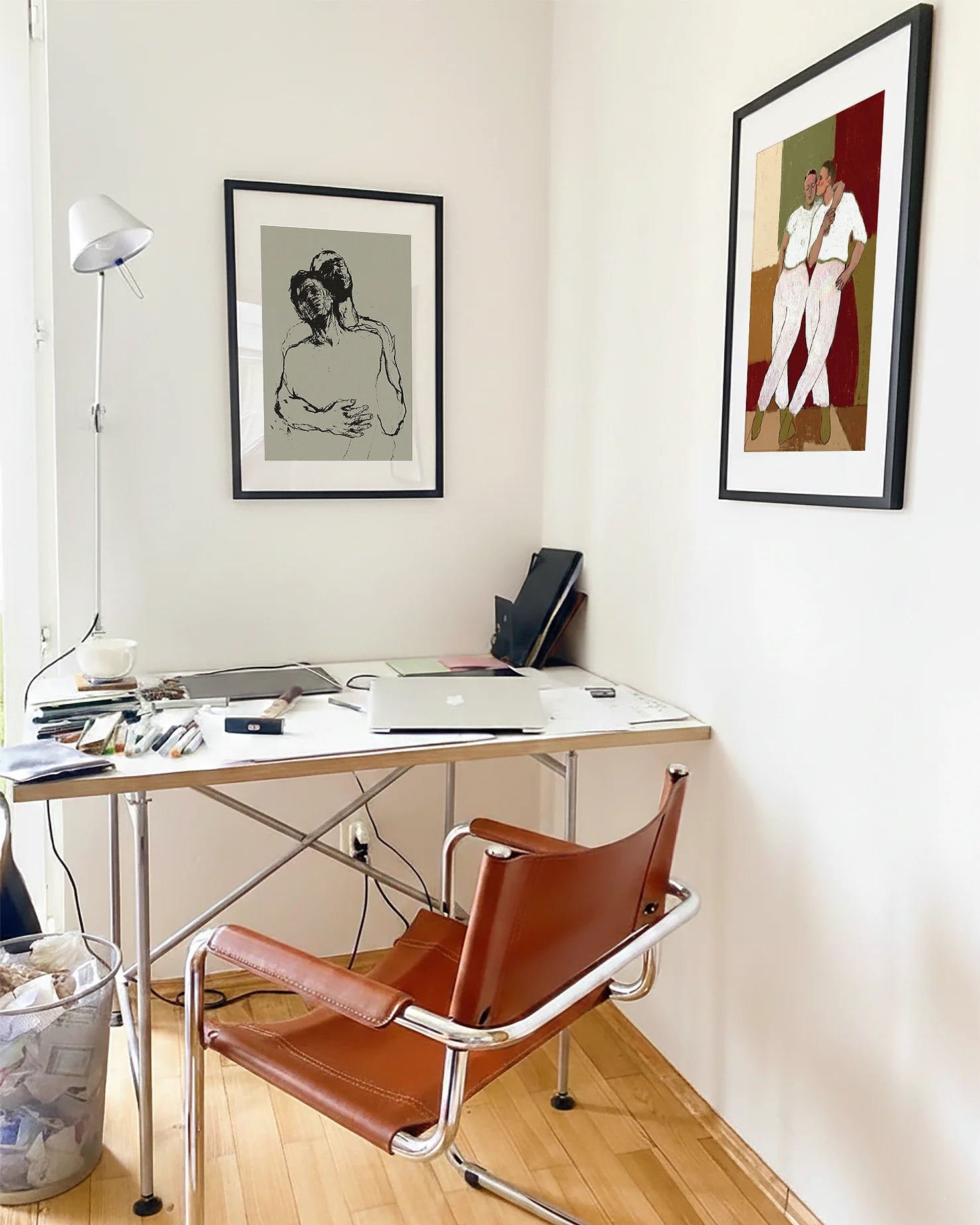 A photo with two framed, queer posters in an office.