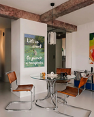 En postern som föreställer en kvinna som plockar blommor i ett öppet fält, i en klassisk oljemålnings-stil med texten 'Life is short Go punch a homophobe".