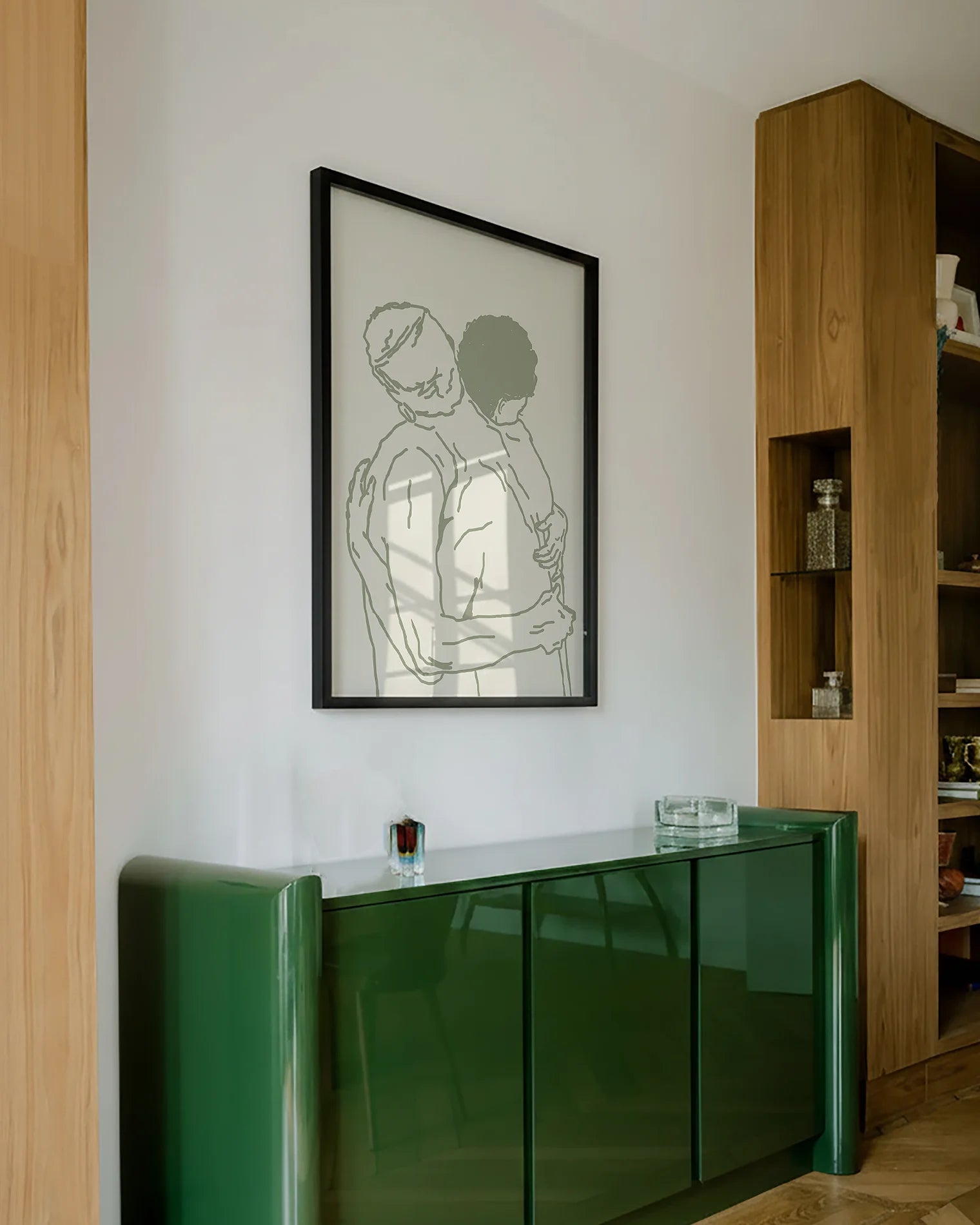A framed poster with two naked men hugging, lineart style.