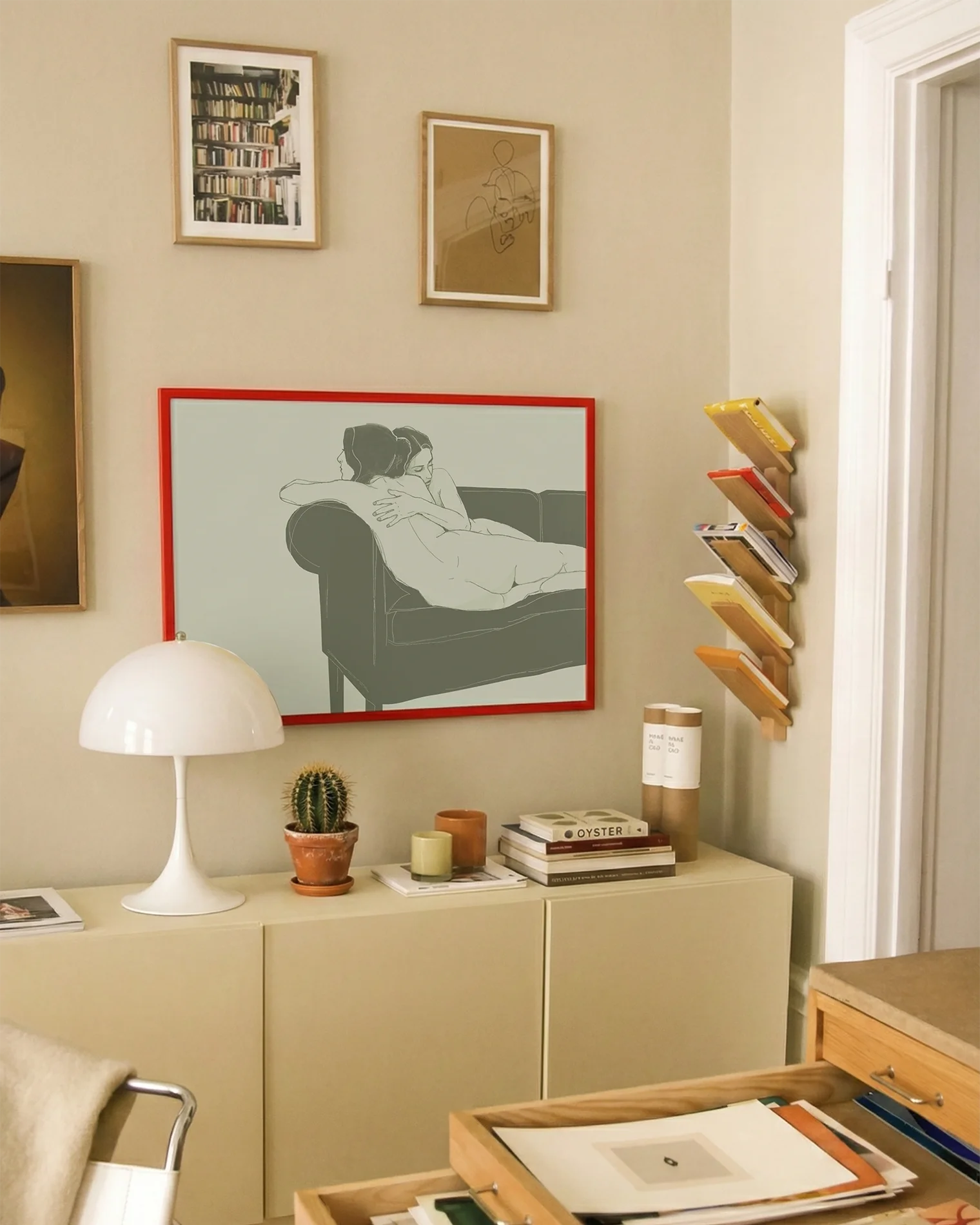 A framed, horizontal poster with two naked, lesbian ladies hugging tight on a couch.